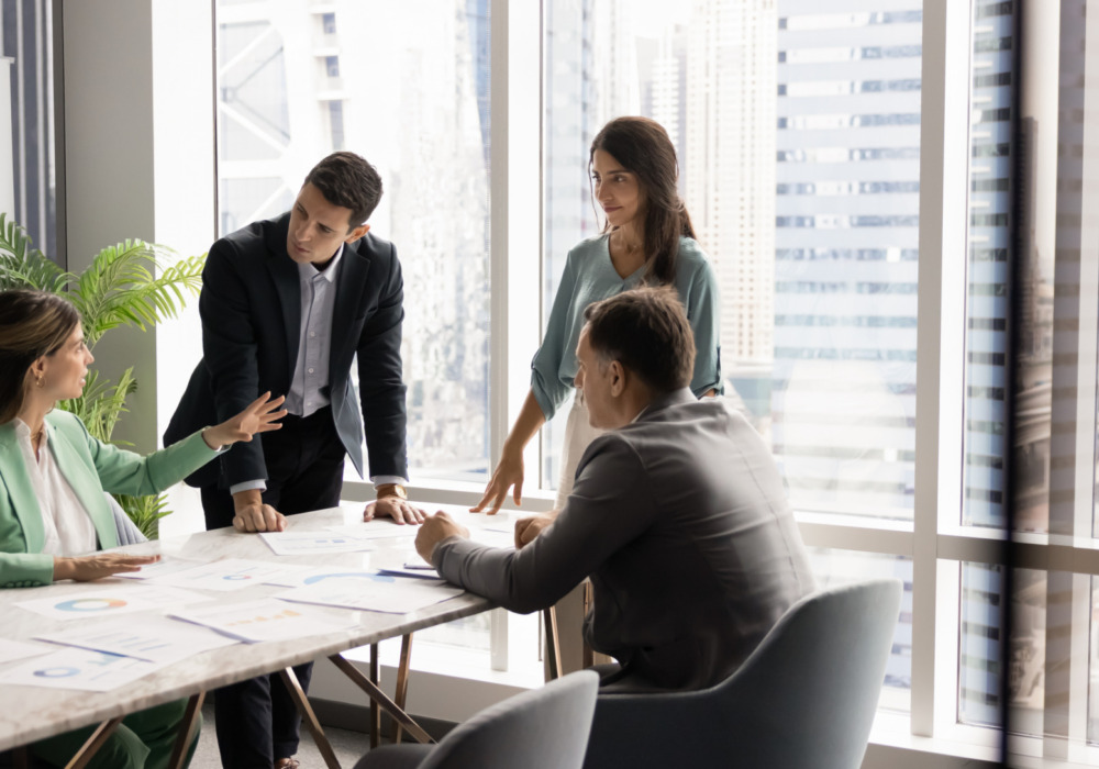 Group of professionals having a meeting in a modern office with cityscape view.