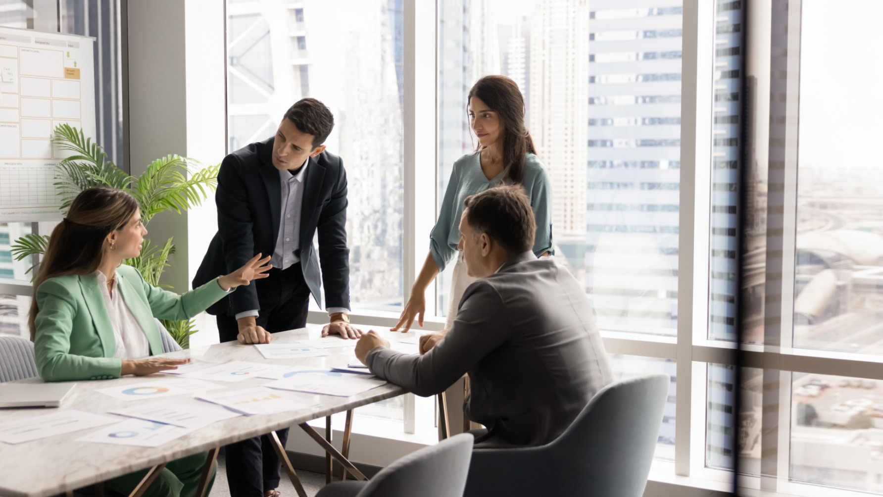 Group of professionals having a meeting in a modern office with cityscape view.