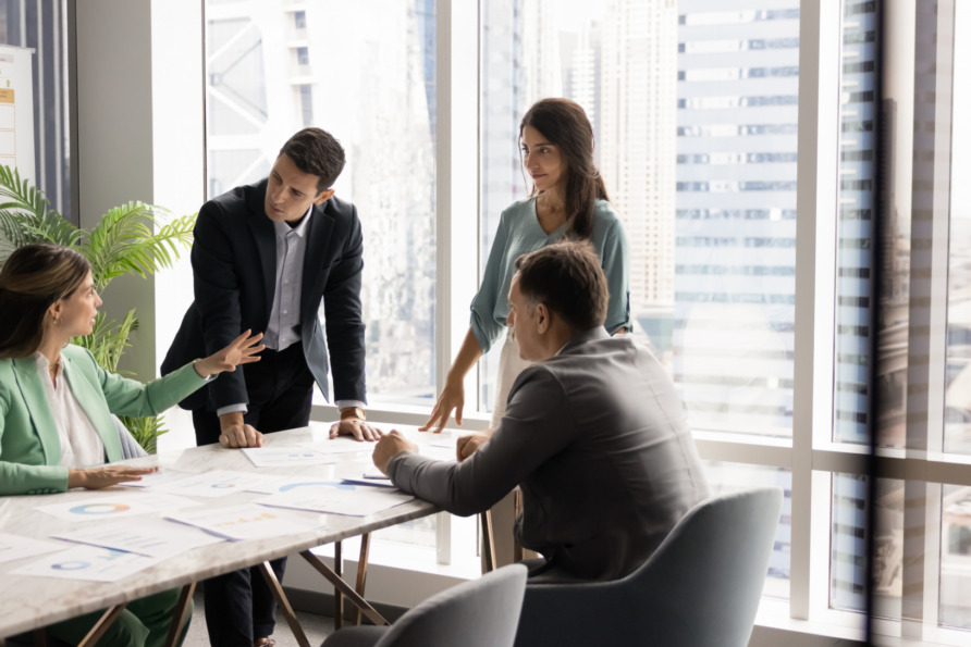 Group of professionals having a meeting in a modern office with cityscape view.